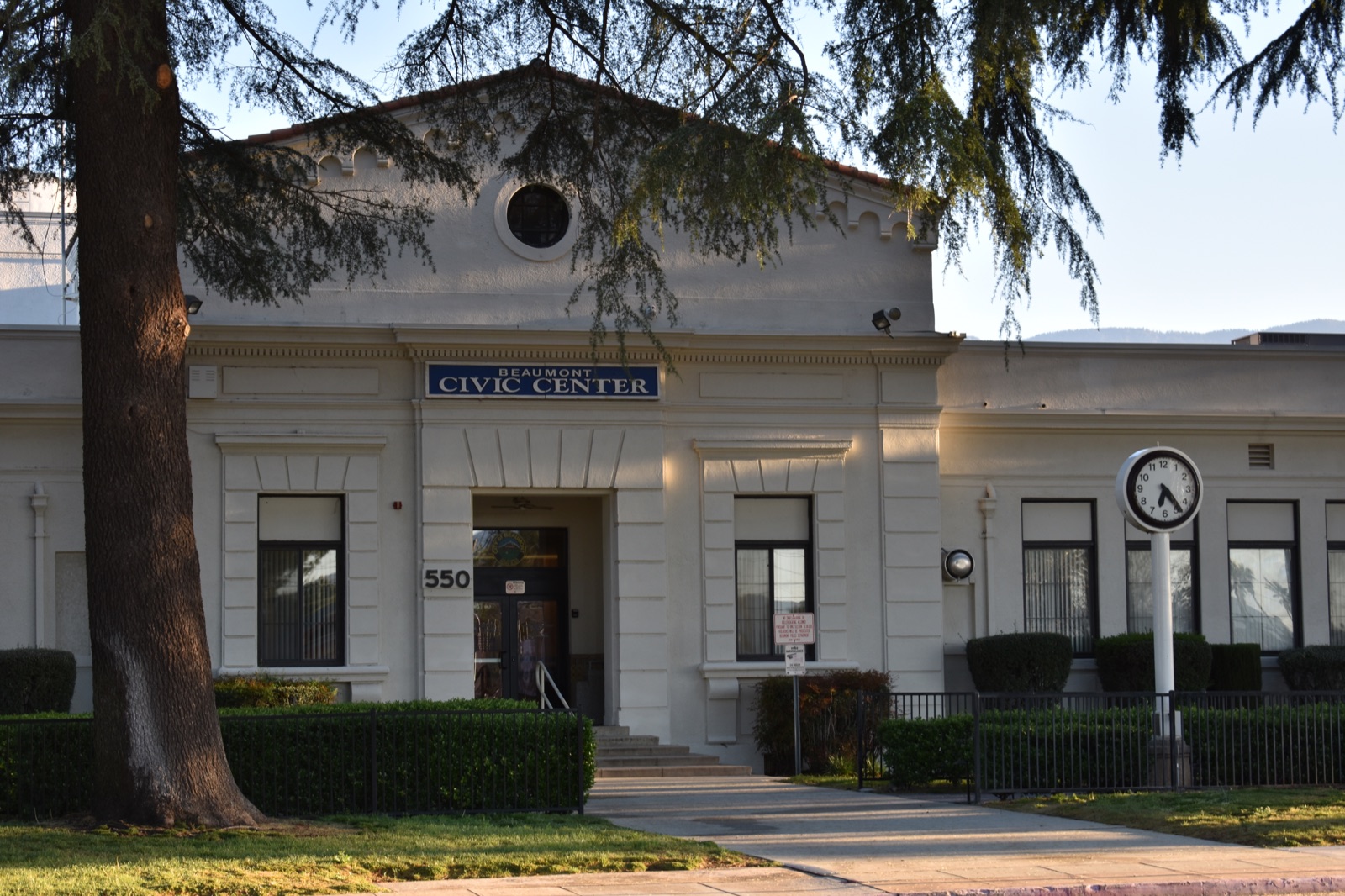 The Beaumont Civic Center entrance shaded by a large tree in early morning light.